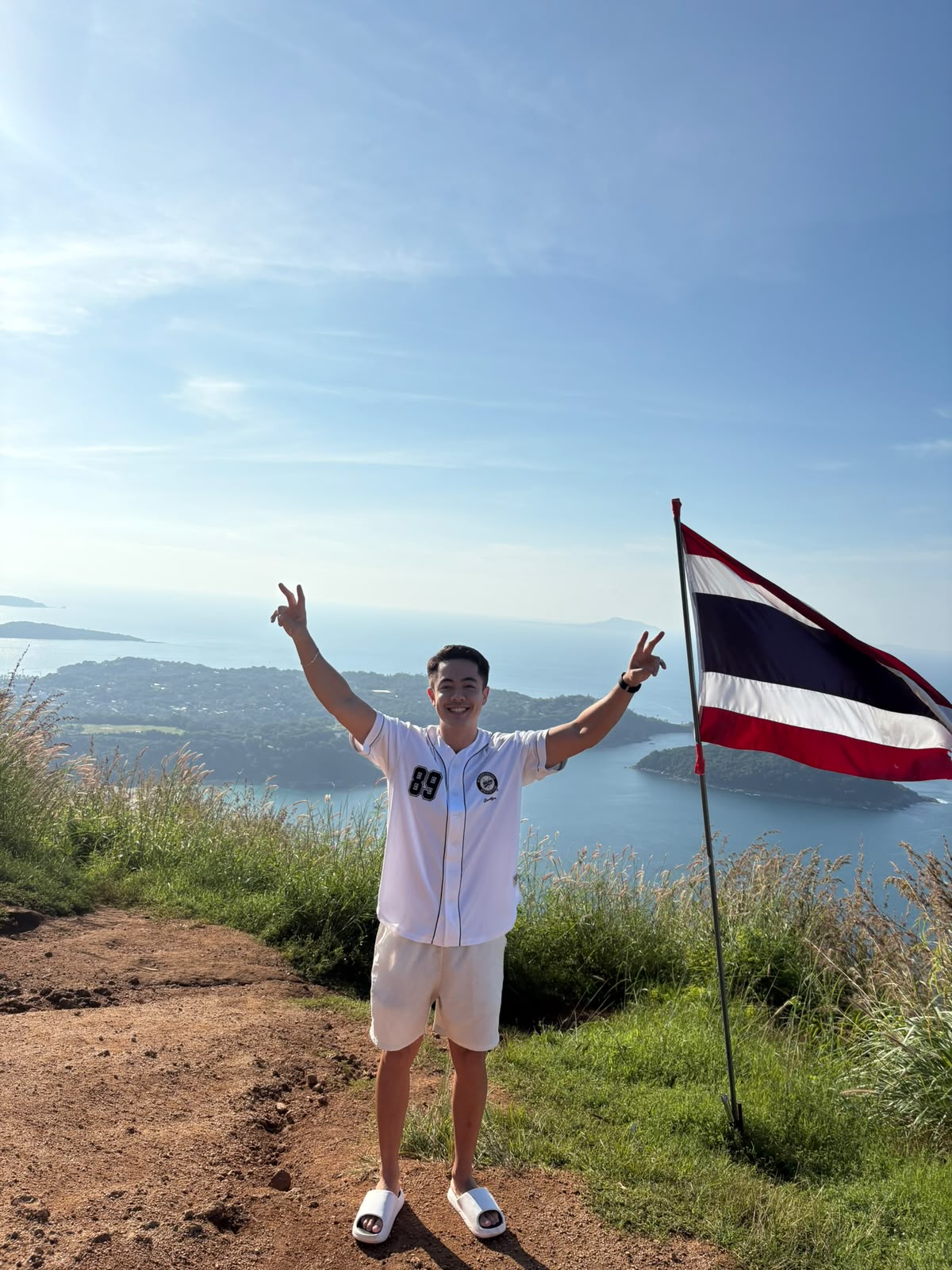 No topo do mirante com a bandeira da Tailândia